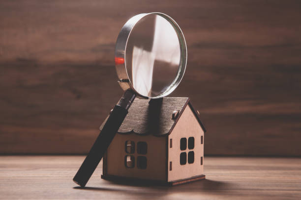istock house model and magnifying glass on a table 2193220469