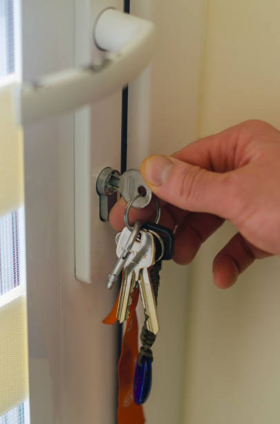 istock Hand Locking Door with Keys in Keyhole Close-Up 2193221407