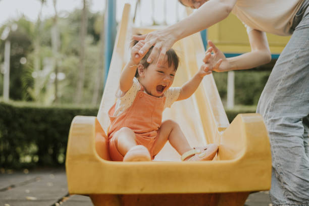 istock a helping hand of mother while having a rest time of kids while playing  the slider. 2193222208
