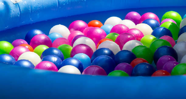 istock Colorful plastic balls fill an inflatable pool in a playful summer setting 2193223019