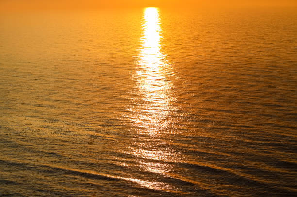 The glow of the setting sun is reflected in the water of the Baltic Sea in Ustronie Morskie, Poland.