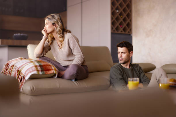 Displeased couple having problems in their relationship at home.