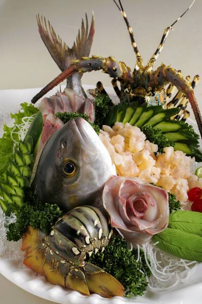 Seafood platter featuring fresh fish, lobster, and vegetables arranged artistically on a plate