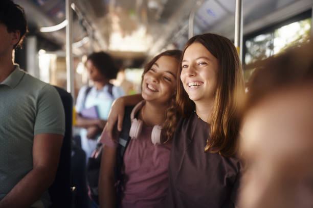 istock Happy schoolgirls embracing while traveling by a bus. 2193225626