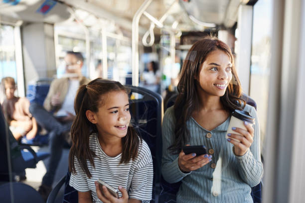 istock Happy mother and daughter using mobile phones while traveling by bus. 2193225689