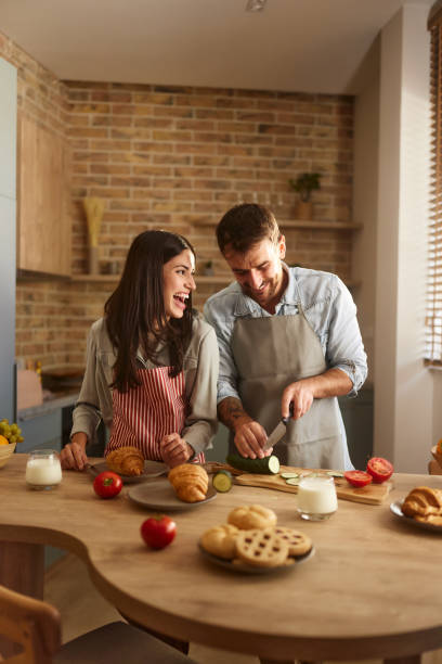 Cheerful couple preparing a meal in the kitchen.