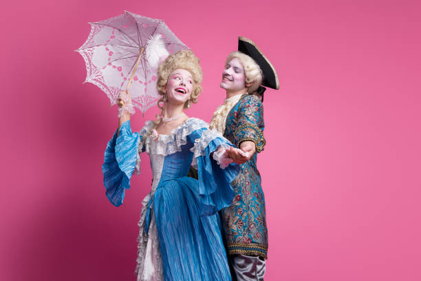 istock Joyful couple dressed in elegant baroque costumes against a pink backdrop, capturing the essence of a royal themed party 2193227396