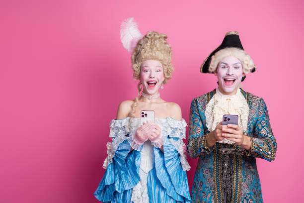 istock Charming young couple dressed in elaborate baroque costumes, posing joyfully against a vibrant pink background 2193227476