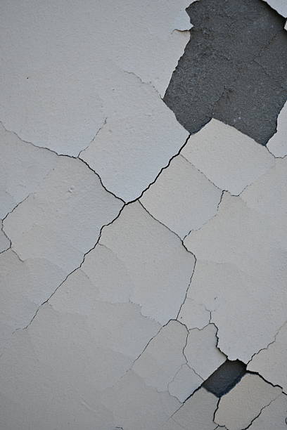 istock white chipped paint on the wall as a background, white old paint on a grey wall 2193229157