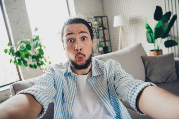istock Young man making a playful selfie in a stylish living room interior 2193231005