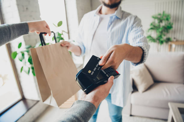 istock Young man making a contactless payment at home during a delivery 2193231097