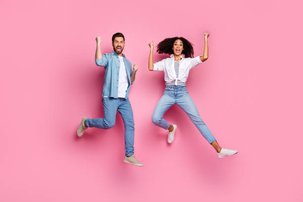 istock Two young friends jumping joyfully on a pink background 2193231423