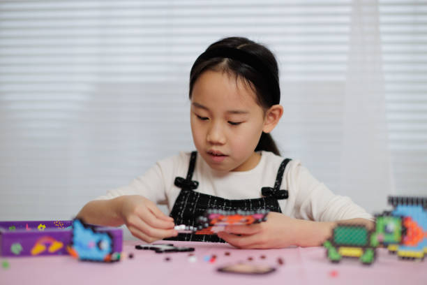 Children's hands assembling blocks to build a toy. In the development of small hand muscles. Select Focus.