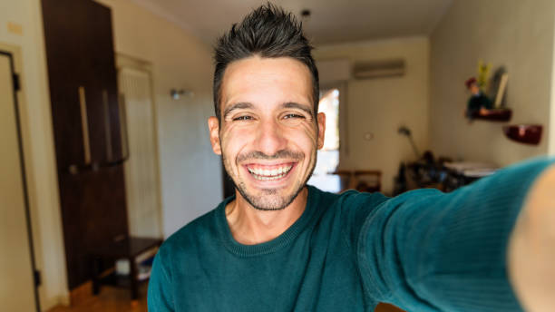 istock Happy handsome guy taking selfie with smartphone at home - Laughing guy looking at camera - People and technology concept 2193242128