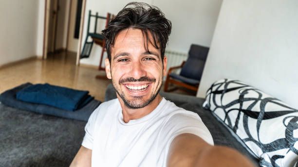 istock Happy handsome guy taking selfie with smartphone at home - Laughing guy looking at camera - People and technology concept 2193242236