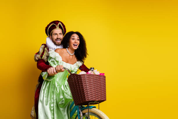 istock A Couple Dressed as Aristocrats Enjoying a Bicycle Ride on a Bright Yellow Background 2193242822