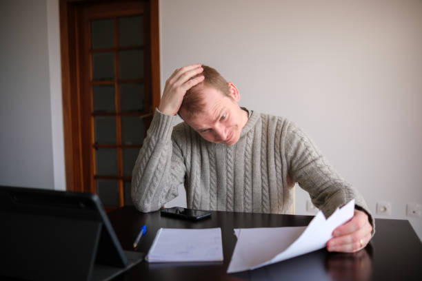 istock Man looking at his invoices and doing math on his notebook and tablet 2193243067
