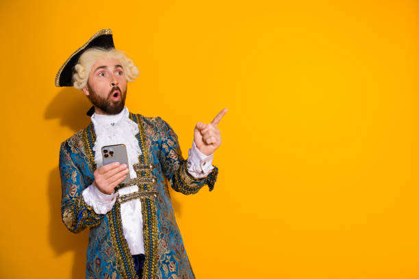 istock A young man in historical costume using a smartphone on yellow background 2193245687