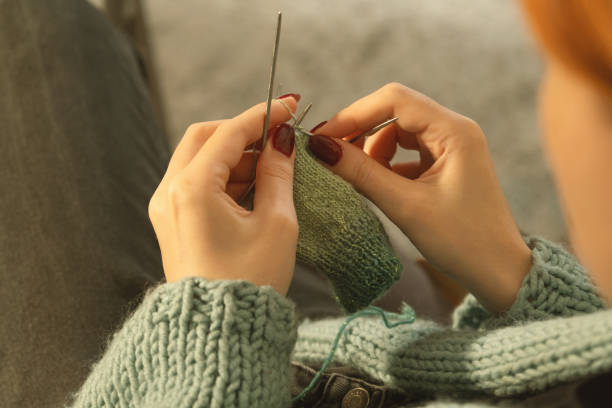 istock Close-up of hands knitting with green yarn 2193246457