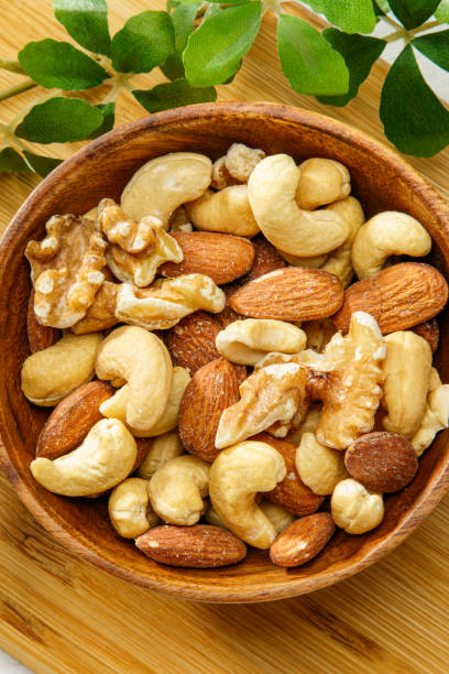 istock Assortment of nuts in wooden bowl 2193247448