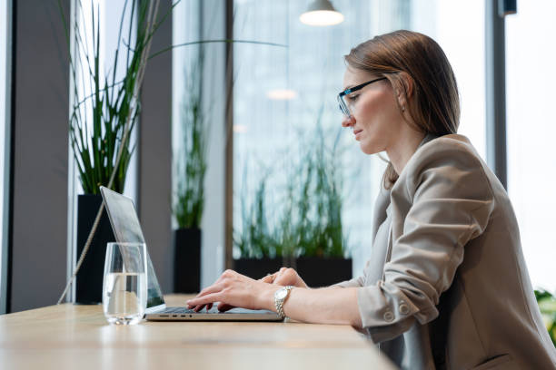 istock Professional Woman Working on Laptop in a Bright Office Space 2193247489