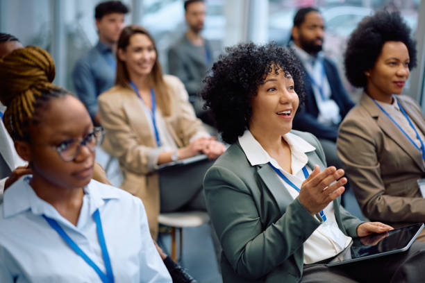 istock Happy female manager asking a question from the audience while participating in business seminar. 2193247511