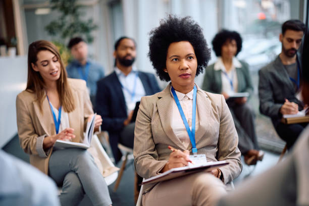 istock Black female manager writing in notebook during business seminar in conference hall. 2193247717