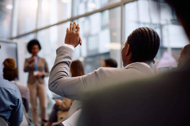 istock Rear view of black businessman asking a question on a conference in board room. 2193247990