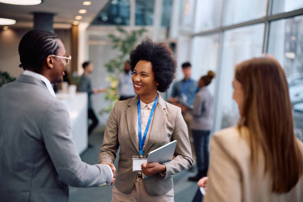 istock Happy entrepreneurs shaking hands while greeting during business seminar in conference hall. 2193248042