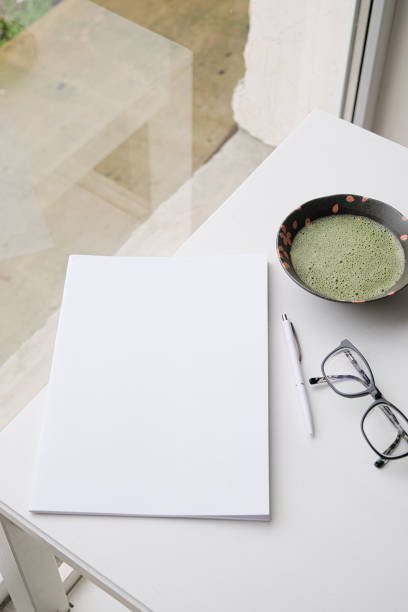 blank magazine mockup on coffee table with green matcha tea near window