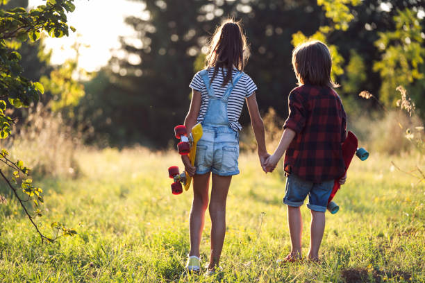 istock Children hold hands with skateboards in sunset park 2193252053