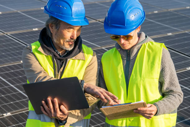istock Mature Asian Male and Caucasian Female Technicians Analyzing Solar Panels 2193253503