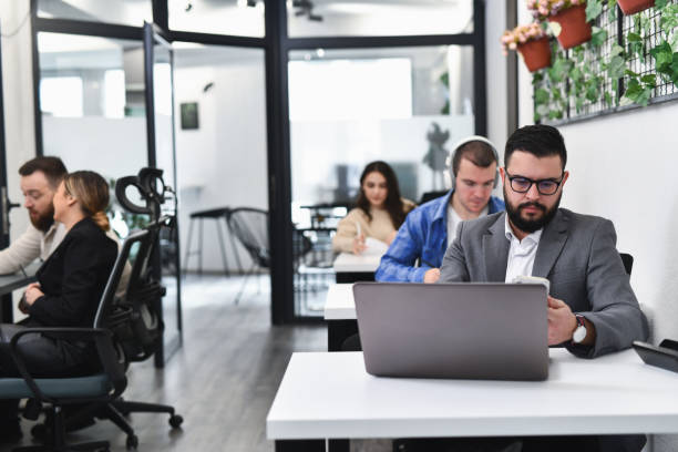 istock Male Financial Advisor Looking at Smart Phone While Working on Laptop From Office 2193261210