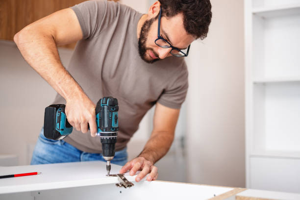 istock Skillful Carpenter Installing New Kitchen Cabinets in Modern Apartment 2193263144