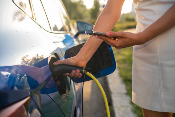 istock Close up woman hands using smart phone for payment for charging electric car. 2193265316