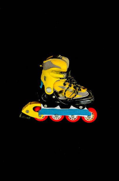 A yellow and black skateboard with red wheels. The skateboard is the main focus of the image