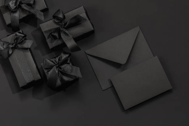 istock Black gift boxes and a black envelope on a dark black background with space for text. Congratulations, postcard. 2193267260