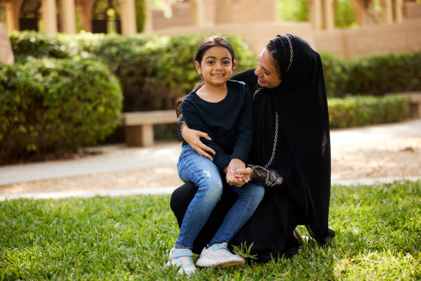 istock A mother and daughter smile at each other while sitting in the park. 2193267714