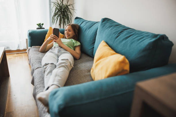 istock Teen Girl Using Smart Phone While Having Leisure Time At Her Home 2193274096