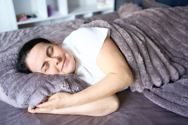 istock a senior woman in silk eye mask sleeping under heavy blanket 2193277042