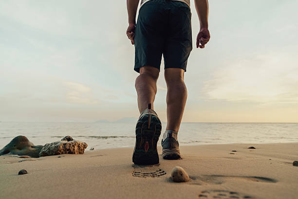 istock walk in sneaker on the beach, closeup 2193277398