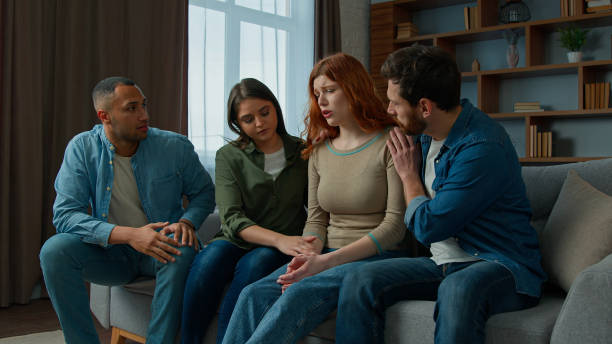 istock Sad desperate girl talk share problem with friends in group psychological therapy at home diverse ethnic women men help upset girl. Caring multiracial teammates listen complaints support give advice 2193278923