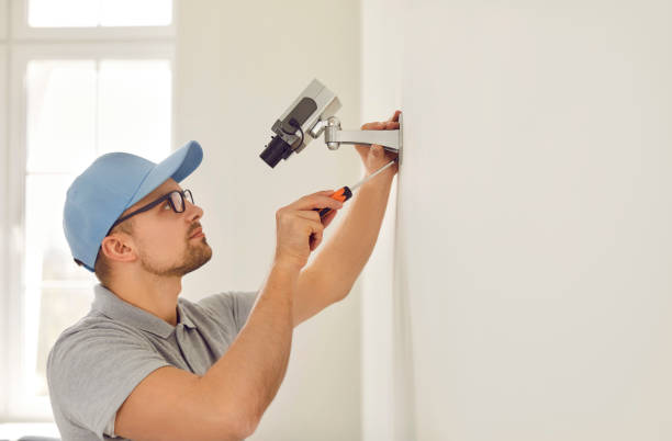 istock Professional male surveillance camera installer mounts it on wall inside new home or office. 2193279012