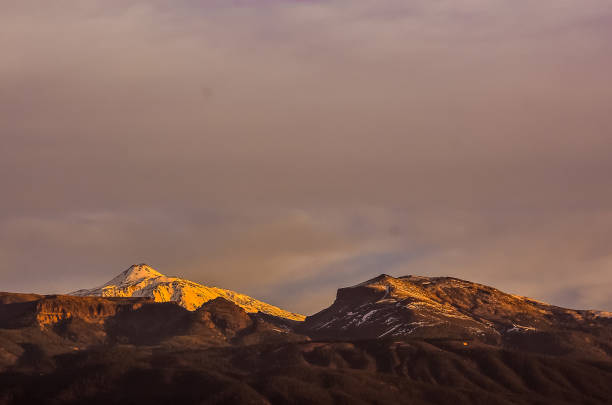 istock The mountains are covered in snow and the sun is setting behind them 2193279210