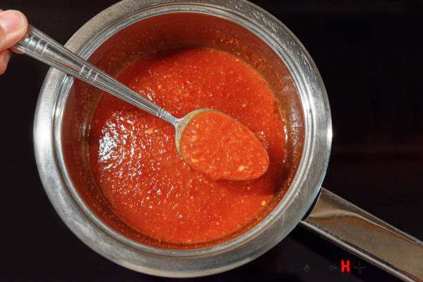 istock Tomato sauce with spoon in pan. Making red sauce in kitchen. Top view 2193279656