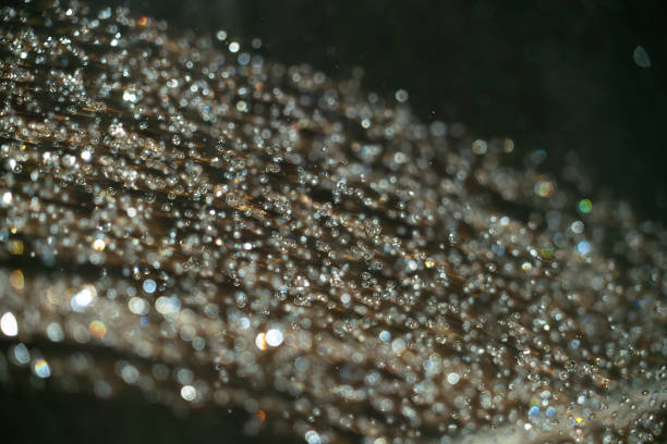 Delicate morning dew droplets suspended on a spider web with soft pastel colors and dreamy blurred background