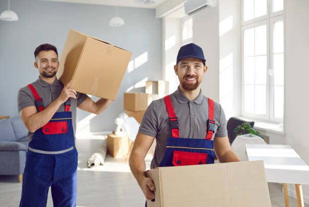 istock Two smiling delelivery men or transportation workers carry cardboard boxes for moving to apartment. 2193281459