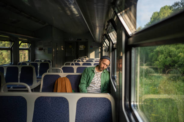 istock Sleepy man worn out from demanding workday, naps on an empty train ride home. Early rise, exhaustion 2193282784