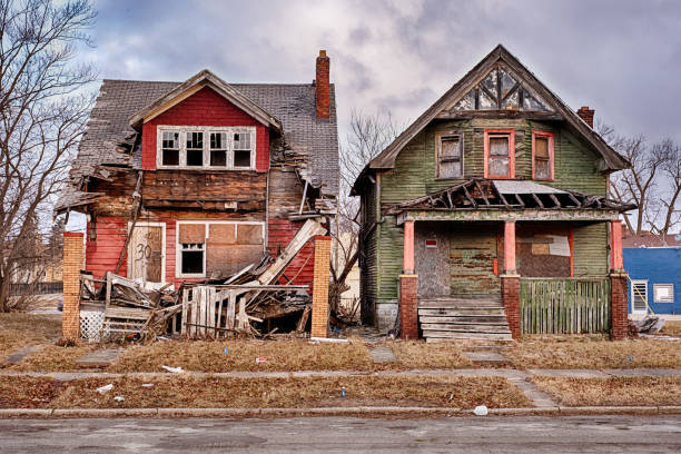 Two Houses Slowly Decaying In Highland Park Two houses in Highland Park, one red and one green, are slowly collpasing as the weather and elements cause them to decay. run down neighborhood stock pictures, royalty-free photos & images