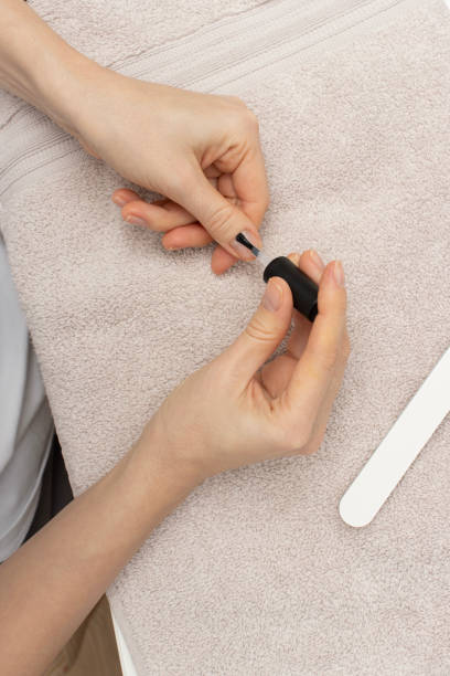 istock A close-up view of hands applying clear nail polish during a manicure process.  self-care. beauty tutorials or nail care promotion. 2193289686